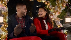 A man and woman smile at each other while riding a sleigh