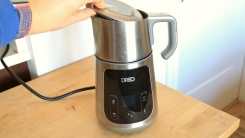 A hand putting the lid on the Dreo BaristaMaker.