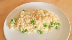 A spoonful of risotto on a white plate.