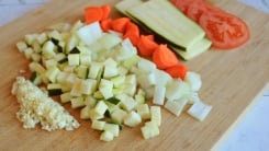 A cutting board with many vegetables cut different ways.
