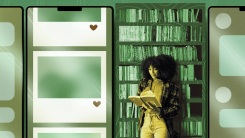 a woman stands in front of a bookcase reading, with large phones in the background