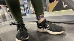 The author's feet, standing on a treadmill in black Nikes, wearing an Apple Watch around her ankle