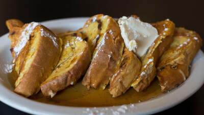 A plate of triangular french toast with butter.