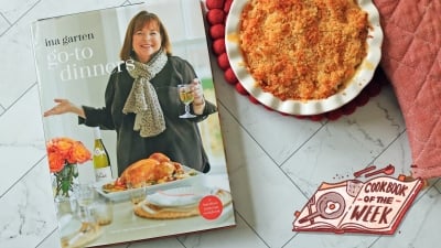 Go-To Dinners cookbook on a table next to mac and cheese and an oven mitt.