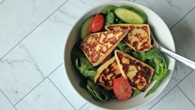 A leafy salad with griddled fried cheese on top. 