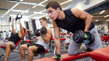 bros lifting dumbbells in the gym