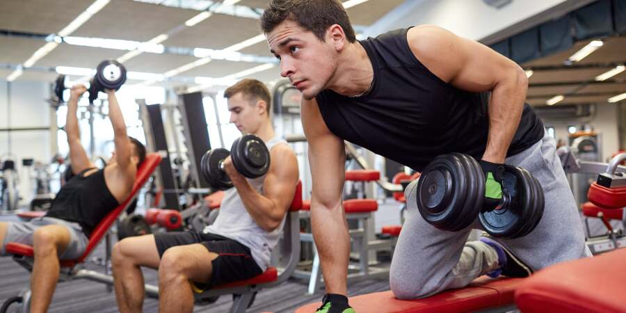bros lifting dumbbells in the gym