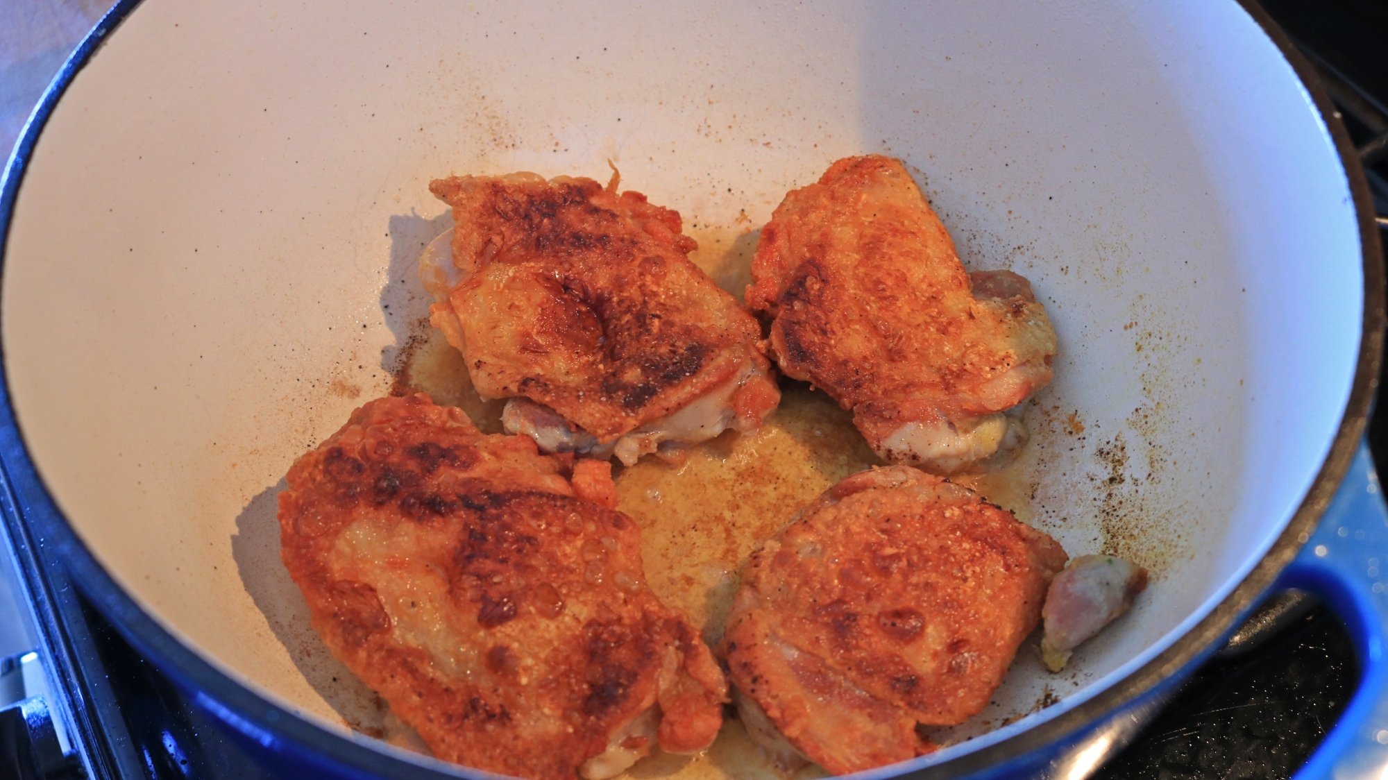 Chicken thighs in a cast iron Dutch oven.