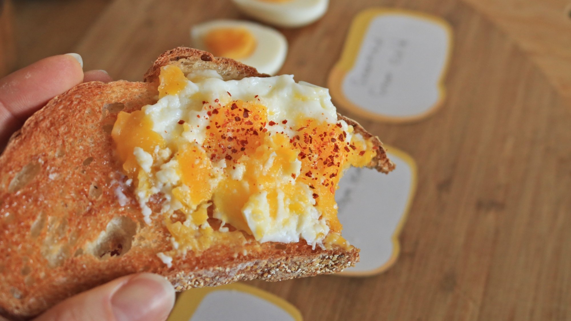 A crushed boiled egg on a slice of toast.