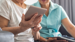 elderly woman holding a tablet in her hands