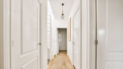 A long hallway with white walls and wood floors