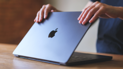 A person closes their macbook lid