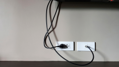 cords hanging against a wall from a tv