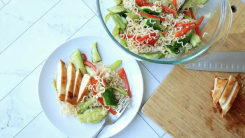 A plate of ramen noodle salad and a side of sliced chicken.