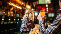 Fans watching match and drinks beer in sports bar
