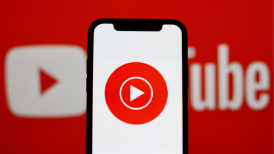 YouTube Music logo on a phone over the YouTube logo in the background