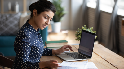 Woman focused on laptop work.