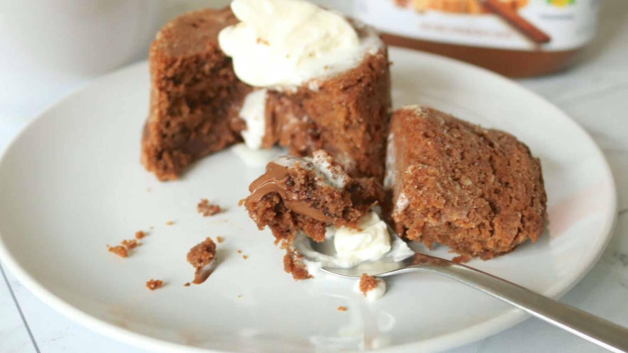 A chocolate lava cake broken open on a plate.
